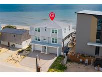 Beachfront home featuring gray siding, a two-car garage and direct access to the beach at 6883 S Atlantic Ave, New Smyrna Beach, FL 32169