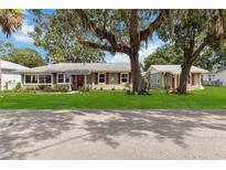 Charming single-story home featuring a well-manicured lawn, mature trees, and inviting curb appeal at 132 E Turgot Ave, Edgewater, FL 32132