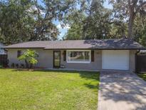 Charming single-story home with a well-maintained lawn and a driveway leading to an attached garage at 1421 Pine Tree Dr, Edgewater, FL 32132
