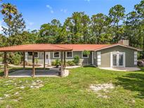 Charming single-story home with a red tile roof and covered parking at 156 S State Road 415, New Smyrna Beach, FL 32168