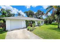 Charming single-story home with a well-maintained lawn and mature trees at 1903 Willow Oak Dr, Edgewater, FL 32141