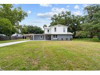 Charming two-story home with well-maintained lawn and gray and white exterior at 2005 Sunny Ln, New Smyrna Beach, FL 32168