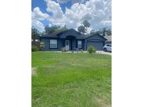 Charming single-story home with well-manicured lawn, stylish paint, and attached garage at 2122 Orange Tree Dr, Edgewater, FL 32141