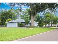 Charming single-story home featuring a well-maintained lawn, mature trees, and a classic gray exterior paint scheme at 2548 Crestwood Ave, New Smyrna Beach, FL 32168