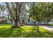 Charming single-story home featuring a well-maintained lawn and mature trees at 2617 Pine Tree Dr, Edgewater, FL 32141