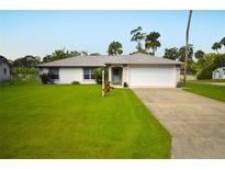 Charming single-story home with a well-manicured lawn and a two-car garage at 2944 Mango Tree Dr, Edgewater, FL 32141