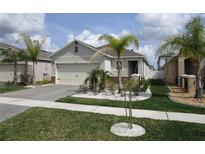 Charming single-Gathering home featuring a well-manicured lawn, decorative stone accents, and a two-car garage at 349 Caryota Ct, New Smyrna Beach, FL 32168