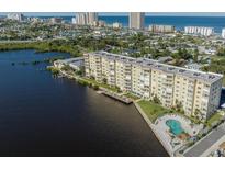 Waterfront condo building with lush landscaping, private pool, and ocean views in a coastal community at 3606 S Peninsula Dr # 406, Port Orange, FL 32127