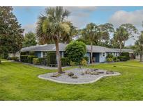 Charming single-story home with a well-manicured lawn and tropical landscaping in a serene setting at 38 Fairway Cir, New Smyrna Beach, FL 32168