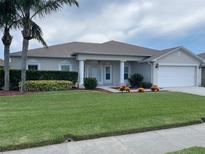 Charming single-story home features a well-maintained lawn and inviting front porch with classic column detailing at 405 Central Mariners Dr, Edgewater, FL 32141