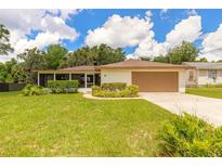 Single story home with a two car garage, screened-in porch and a well manicured lawn at 5060 Audubon Ave, De Leon Springs, FL 32130