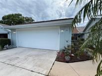 Attached garage with white door and well manicured landscaping, including rock beds and trimmed bushes at 51 Fore Dr, New Smyrna Beach, FL 32168