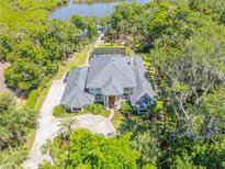 Stunning aerial view of a beautiful home with lush landscaping, circular driveway and waterfront access at 6325 Palmas Bay Cir, Port Orange, FL 32127