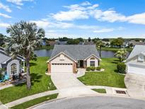 Beautiful single-story home featuring a well-manicured front yard and a tranquil lake view at 684 Rochester Ct, New Smyrna Beach, FL 32168