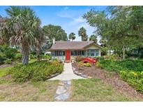 Charming home with a red door and a red bridge in the landscaped front yard at 807 Craig St, New Smyrna Beach, FL 32168