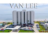 A luxury white high-rise condo building, named Van Lee, sits on a beach with a parking lot in front and ocean views at 1051 Ocean Shore Blvd # 502, Ormond Beach, FL 32176