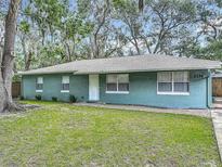 Inviting single-story home featuring a well-maintained lawn and a charming facade with mature landscaping at 1331 Needle Palm Dr, Edgewater, FL 32132