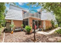 Charming two-story home with a balcony, screened-in porch, well-maintained landscaping, and unique architectural details at 4150 S Atlantic Ave # 111B, New Smyrna Beach, FL 32169