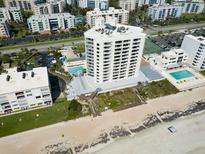 Stunning aerial view of the beachfront condo with pools, tennis courts, and easy beach access at 5207 S Atlantic Ave # 224, New Smyrna Beach, FL 32169