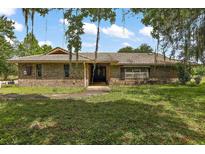 Charming single-story brick home with a tile roof, mature trees, and a spacious front yard at 10290 Buck Rd, Orlando, FL 32817