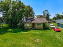 Charming single-story home featuring a chimney, a well-maintained lawn, and mature trees at 966 N Ronald Reagan Blvd, Longwood, FL 32750