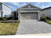 Charming one-story home featuring a two-car garage and a beautifully paved driveway and walkway at 1225 Atlantic Ave, Fruitland Park, FL 34731