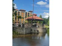 Picturesque gazebo situated on a stone foundation by the water, perfect for relaxing outdoors at 12521 Floridays Resort Dr # 302F, Orlando, FL 32821