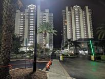 Night view of two condo buildings with gated entrance at 13427 Blue Heron Beach Dr # 702, Orlando, FL 32821
