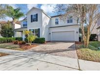 Charming two-story home featuring a two-car garage, brick driveway, and well-maintained landscaping at 9149 Outlook Rock Trl, Windermere, FL 34786