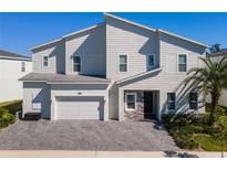 Charming two-story home boasts an attached garage, stone accents, and a well-manicured front yard at 1758 Oak Blossom Dr, Davenport, FL 33837