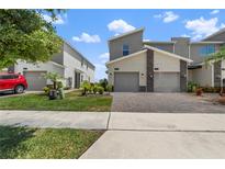 Modern townhomes showcase brick driveways and well-manicured landscaping at 1065 Splash Shot Pl # 1801, Davenport, FL 33896