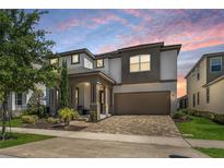 Stunning two-story home showcasing a charming front porch, two-car garage, and beautifully landscaped front yard at 1817 Caribbean View Ter, Kissimmee, FL 34747
