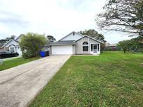 Charming single-story home with well-maintained lawn, attached garage, and welcoming screened porch at 106 Georgia Ave, Saint Cloud, FL 34769