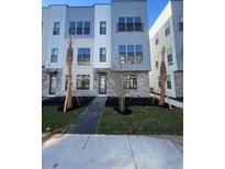 Modern three-story townhome with gray and white exterior, walkway, and landscaping at 2233 Valentine Aly, Orlando, FL 32804