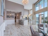 Bright, open living space with floor to ceiling windows and a modern kitchen featuring a beautiful chandelier at 322 E Central Blvd # 401, Orlando, FL 32801