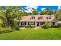 Charming home features a well-manicured lawn, mature trees and manicured shrubs at 731 Keeneland Pike, Lake Mary, FL 32746