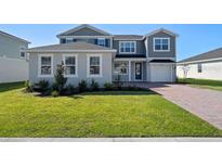 Charming two-story home with landscaped yard and brick paver driveway at 2690 Ginseng Ivy St, Apopka, FL 32703