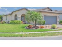 Charming home featuring lush landscaping, a well-manicured lawn, and a beautiful palm tree at 745 Asturias Rd, Davenport, FL 33837