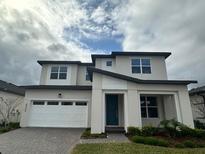 Two-story home with a modern design, two-car garage, and landscaping at 4922 Shady Pines Dr, Saint Cloud, FL 34772