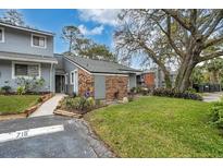 Inviting gray townhome featuring a lush green lawn and mature tree at 716 Saint Matthew Cir, Altamonte Springs, FL 32714