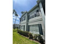 Well-maintained two-story condo with green shutters and lush landscaping at 5156 City St # 118, Orlando, FL 32839