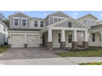 Charming two-story home featuring a two-car garage, stone accents, and a welcoming front porch at 231 Severn Way # 36, Orlando, FL 32803