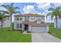 Two-story house with gray siding, brown roof, and a two-car garage at 5205 Cape Hatteras Dr, Clermont, FL 34714