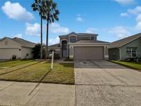 Two-story house with attached garage and landscaped lawn at 340 Troon Cir, Davenport, FL 33897