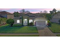 Beautiful one story home showcasing mature landscaping and a well-manicured lawn at dusk at 2855 Gopherwood Way, Clermont, FL 34711