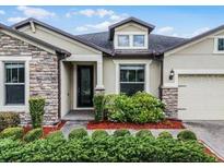 Charming single-story home featuring stone accents, a well-manicured lawn and a two car garage at 30215 Bretton Loop, Mount Dora, FL 32757