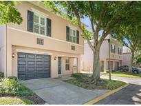 Charming two-story townhouse features a gray garage door, neutral stucco, and black shutters in a residential community at 2748 Clinton Heights Ct, Oviedo, FL 32765