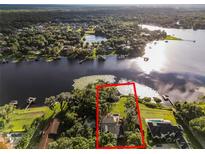 Aerial view of a waterfront house with a private dock and lush landscaping at 1700 Lake Markham Rd, Sanford, FL 32771