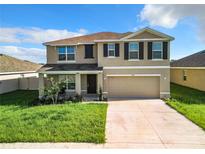 Two-story home features a two-car garage, neutral paint scheme, and manicured lawn at 5043 Sw 88Th Pl, Ocala, FL 34476