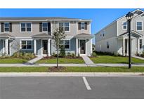 Charming two-story townhome showcasing a welcoming entrance and well-manicured lawn at 3201 Douglas Fir Dr, Apopka, FL 32703